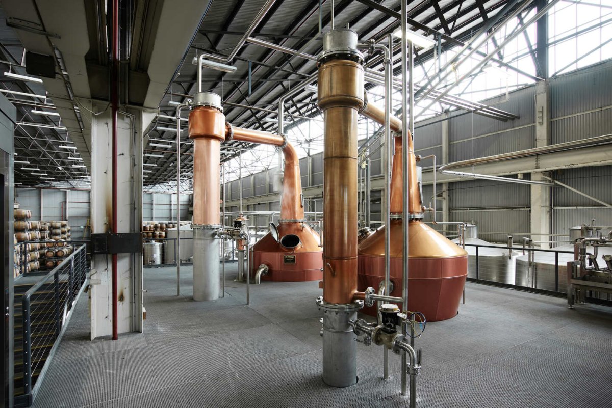 distillery industrial stills copper steel light steam open hatch spirit pipes platform barrels wooden