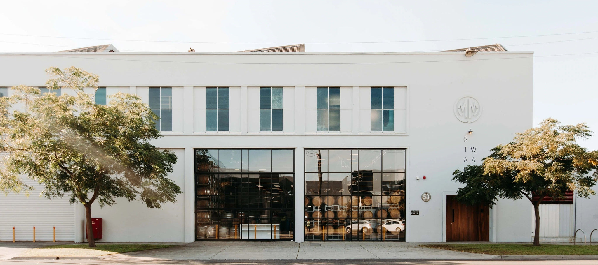 White building green trees Distillery Port Melbourne sun sky day glass windows