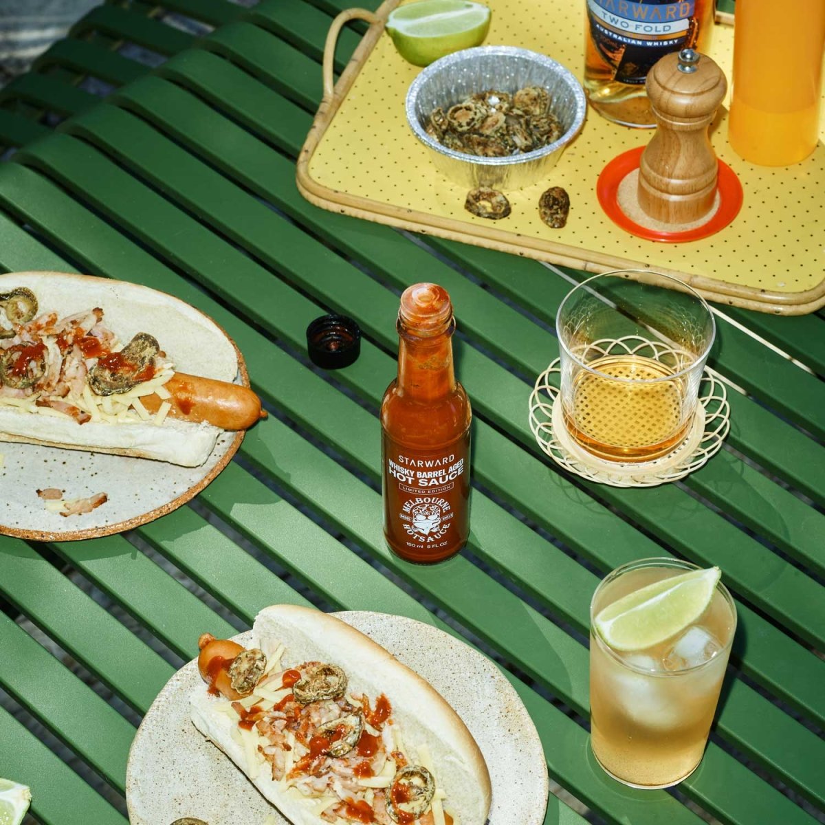 food spread lunch cocktails glass liquids red gold hot sauce bottle