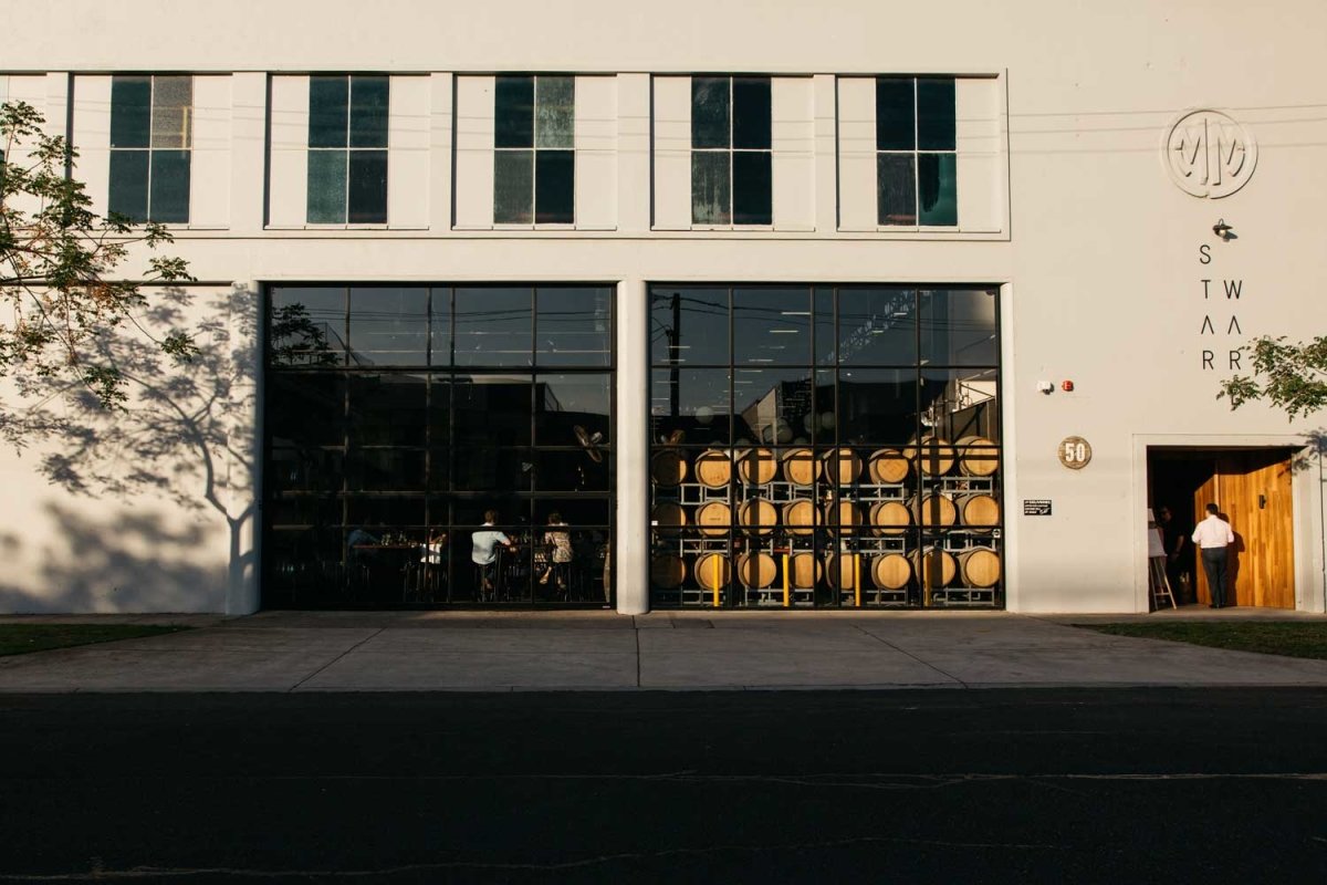 white building black doors Distillery glass windows barrels wooden sunset afternoon shadows